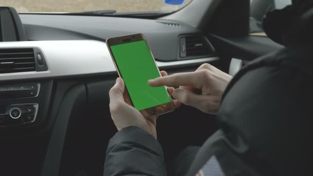 Зелёный крикун держит смартфон в машине. — стоковое видео