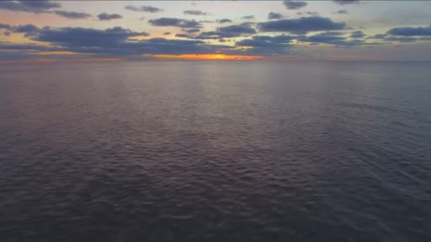 Luchtfoto vliegen over water bij zonsondergang — Stockvideo