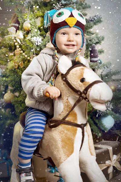Küçük bir çocuk ile bir at-sallanan Noel ağacının etrafında çalış
