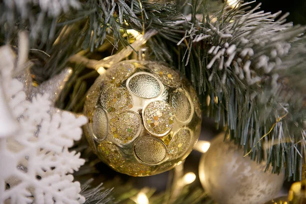 Brinquedo de Natal na forma de uma bola de ouro na árvore de Natal — Fotografia de Stock