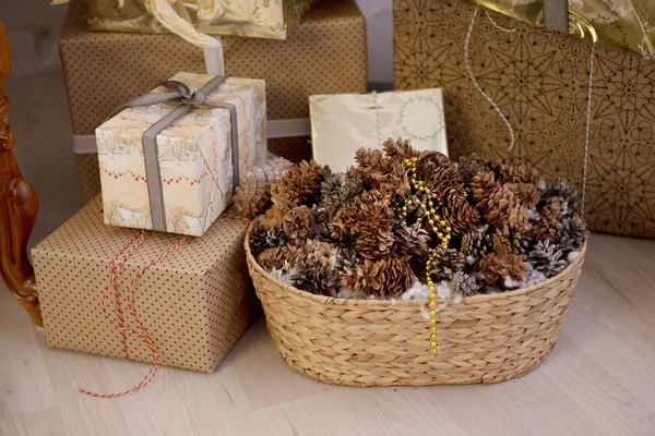 Cones de Natal na cesta entre as caixas de presente — Fotografia de Stock