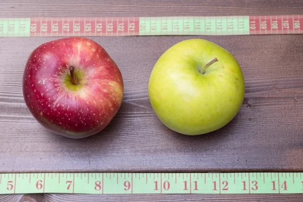 Groene en rode appels met meetlint — Stockfoto