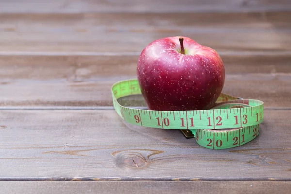 Rode appels met het meetlint op woden tafel — Stockfoto