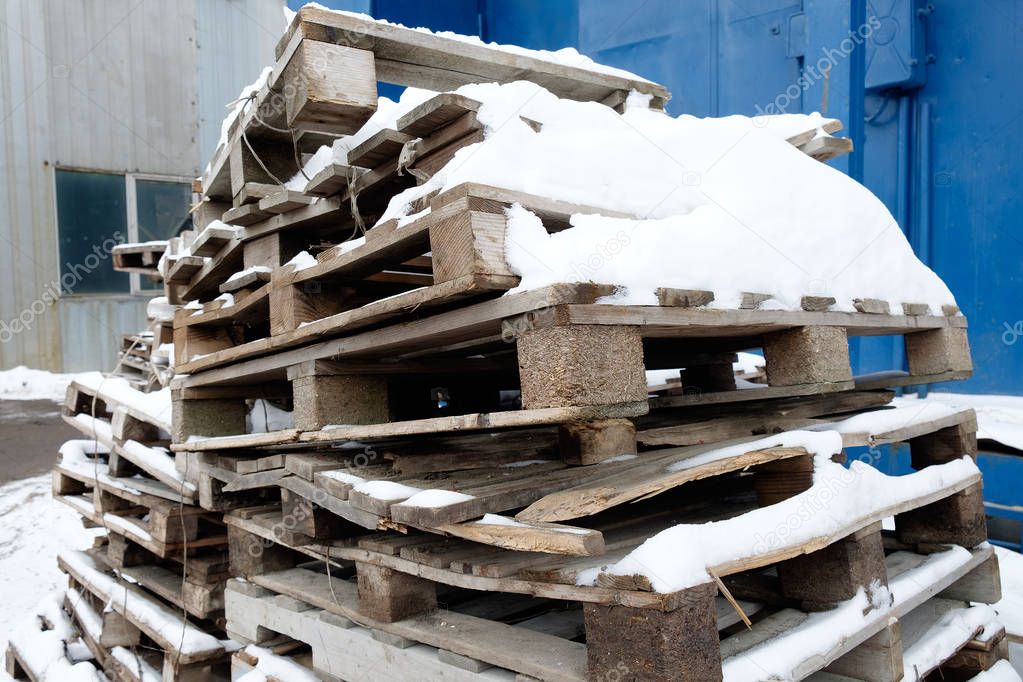 Old wooden pallets with snow