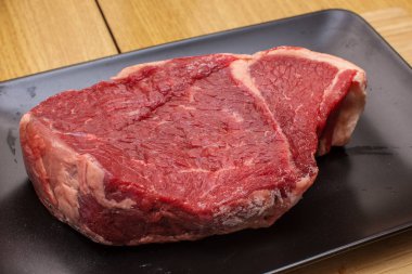 Siyah bir plaka üzerinde ham sığır eti.