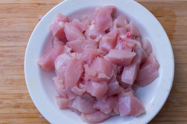 Beyaz ahşap kesme tahtası tabağa dilimlenmiş tavuk fileto