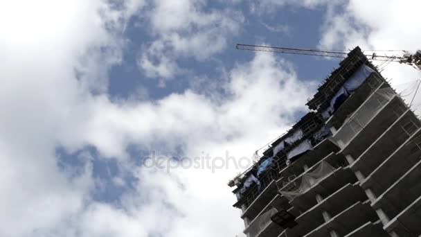 Crane at a skyscraper construction and blue sky with cloud. — Stock Video