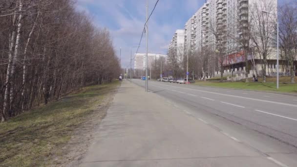 Una vista de la calle de la ciudad con coches que rara vez pasan en un día claro de primavera — Vídeos de Stock