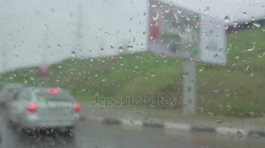 Ön cam üzerinde yağmur damlaları. Camdan arıyorsunuz.