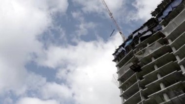 Bulut bir gökdelen inşaat ve mavi gökyüzü, Vinç.