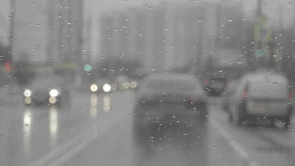 Gotas de lluvia en el parabrisas. Mirando a través del parabrisas . — Vídeos de Stock