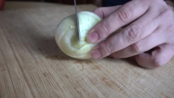 Cebola cortada em uma tábua de madeira. Fechar — Vídeo de Stock