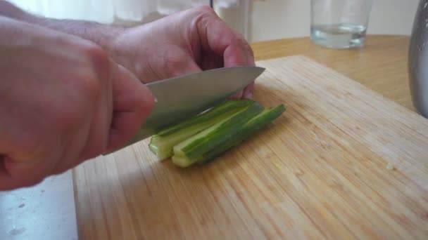 Cortar el pepino en una tabla de madera . — Vídeo de stock