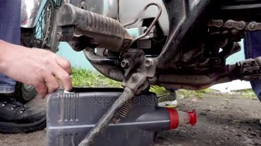 Eski motor yağı bir motosiklet alttan akar