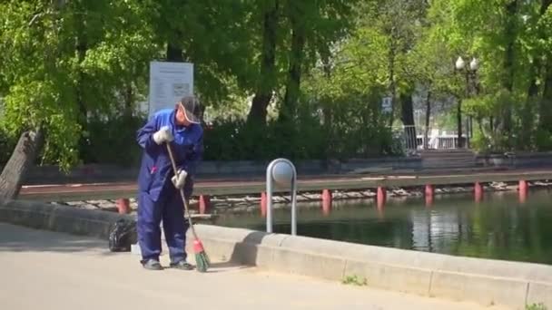 MOSCOW, RUSSIA - May 18, 2017: Janitor sweeps the street in Gorky Park, Moscow, Russia — Stock Video