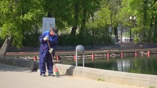 MOSCÚ, RUSIA - 18 de mayo de 2017: El conserje barre la calle en Gorky Park, Moscú, Rusia — Vídeos de Stock