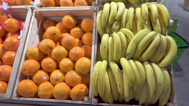 Bananen en sinaasappelen in een supermarkt. — Stockvideo