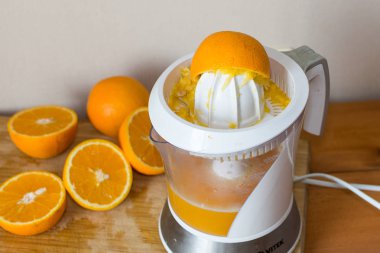 Portakal suyu ve meyve ve ahşap masa üzerinde elektrik suyu makine