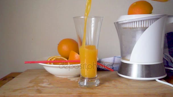 Jugo de naranja se vierte en un vaso — Vídeo de stock