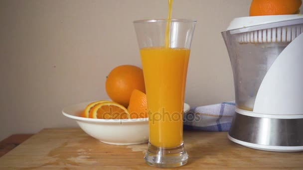 Suco de laranja é derramado em um copo — Vídeo de Stock