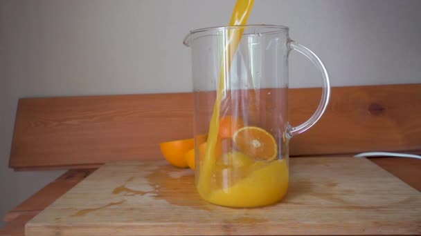 O suco de laranja é derramado em um frasco de vidro — Vídeo de Stock