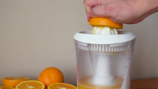 Κάνει φρέσκο χυμό πορτοκάλι με ηλεκτρικό αποχυμωτή — Αρχείο Βίντεο