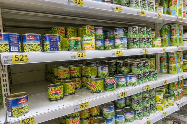 Rusland, Moskou, 11 juni 2017: Verschillende soort ingeblikte groene erwten op de schappen in de supermarkt Auchan — Stockfoto