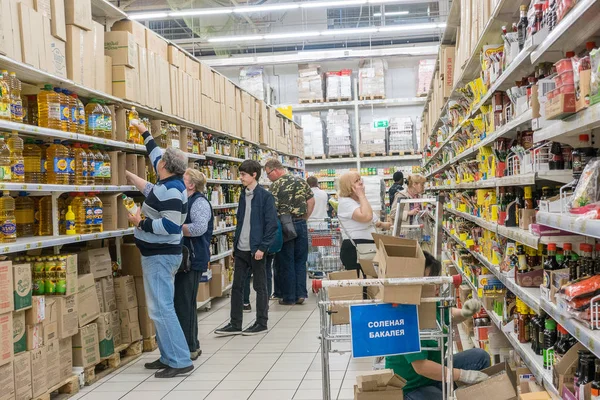 Rusland, Moskou, 11 juni 2017: Mensen winkelen voor uiteenlopende producten in Auchan supermarkt. — Stockfoto