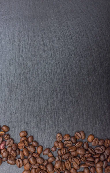 Kahve çekirdekleri arduvaz veya taş arka plan kopya alanı ile siyah arka plan üzerine