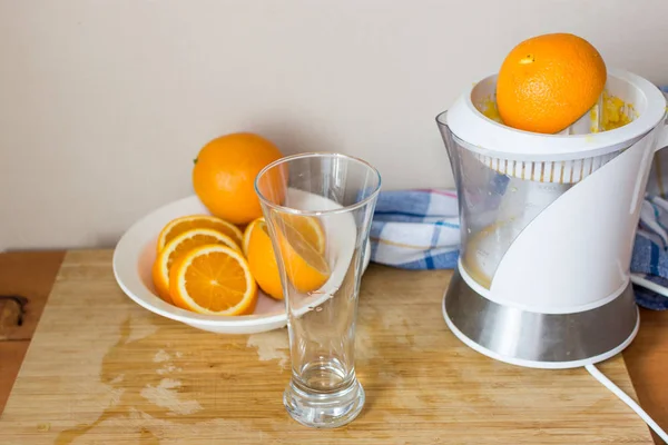Portakal suyu ve meyve ve ahşap masa üzerinde elektrik suyu makine