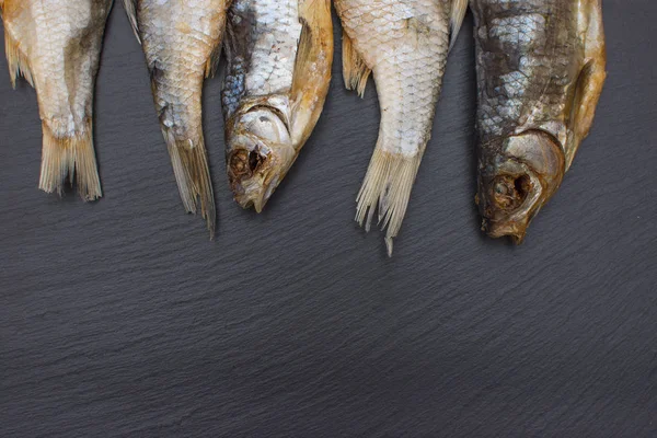 Scarafaggio salato secco su fondo nero di ardesia o pietra . — Foto Stock