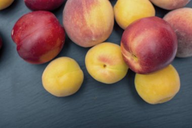 Olgun kayısı ve nektarin kayrak veya taş siyah arka plan üzerine