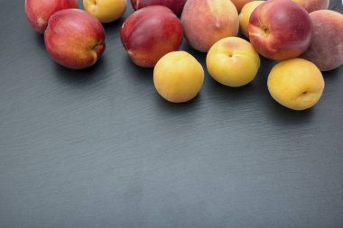 Olgun kayısı ve nektarin kayrak veya taş siyah arka plan üzerine