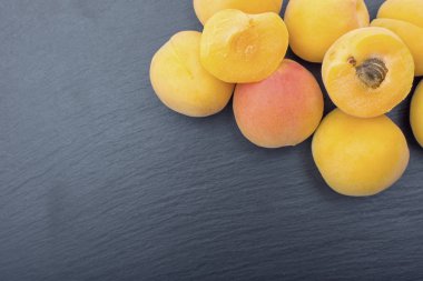 Kayrak veya taş siyah arka plan üzerine olgun kayısı