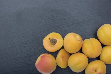 Kayrak veya taş siyah arka plan üzerine olgun kayısı