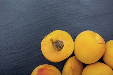 Kayrak veya taş siyah arka plan üzerine olgun kayısı