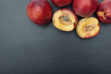 Olgun nektarin kayrak veya taş siyah arka plan üzerine