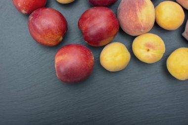 Olgun kayısı ve nektarin kayrak veya taş siyah arka plan üzerine