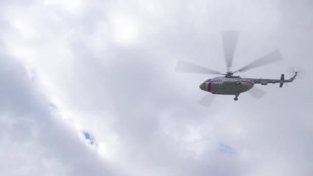 Helikopter vliegen in de bewolkte hemel — Stockvideo