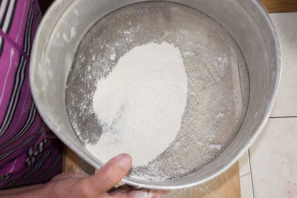 Sifting the flour in a sieve. — Stock Photo, Image