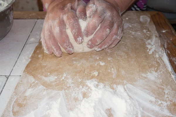 Vue de dessus des mains féminines mélangeant la pâte. Mains féminines pétrir la pâte sur une planche en bois . — Photo