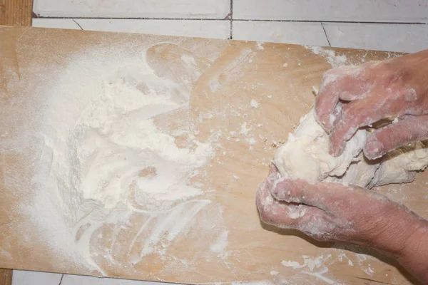 Vue de dessus des mains féminines mélangeant la pâte. Mains féminines pétrir la pâte sur une planche en bois . — Photo
