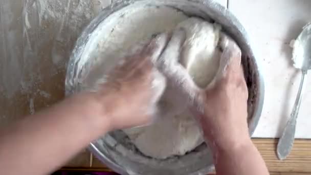 Top view skud af kvindelige hænder blande dej. Kvindelige hænder ælte dej i metal pot . – Stock-video