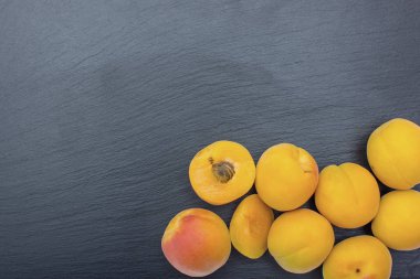 Kayrak veya taş siyah arka plan üzerine olgun kayısı