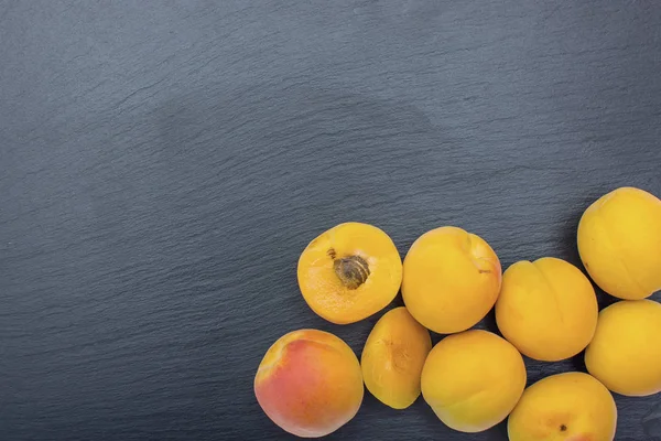 Kayrak veya taş siyah arka plan üzerine olgun kayısı