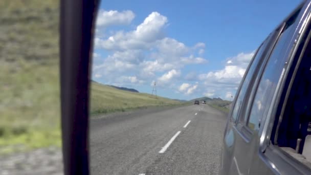 Άποψη του δρόμου στον καθρέφτη αυτοκινήτου πλευρά από το παράθυρο του αυτοκινήτου — Αρχείο Βίντεο