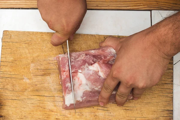 Cortar un trozo de carne en una tabla de cortar de madera — Foto de Stock