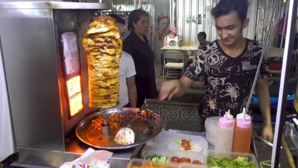 Bangkok, Thailand - 23 December 2017: Man bereidt kebab op Khaosan Road. — Stockvideo