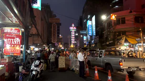 曼谷, 泰国-2017年12月21日: 中国城市之夜点燃中国英语标志在街道附近与繁忙移动的交通人的距离 — 图库视频影像