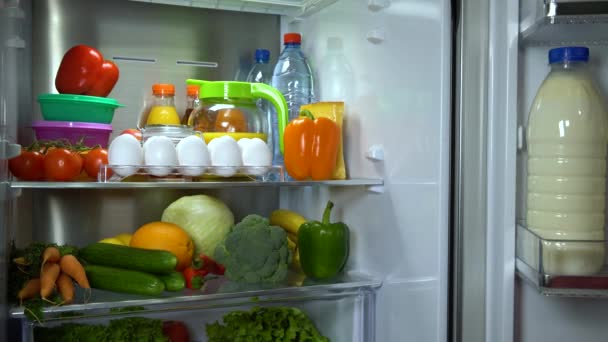 Mujer toma huevos del refrigerador — Vídeo de stock